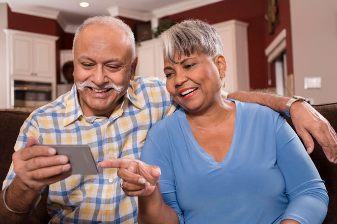 An older couple watching the phone together