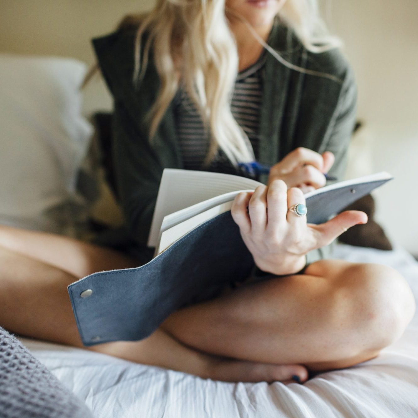 woman writing to do list in bed