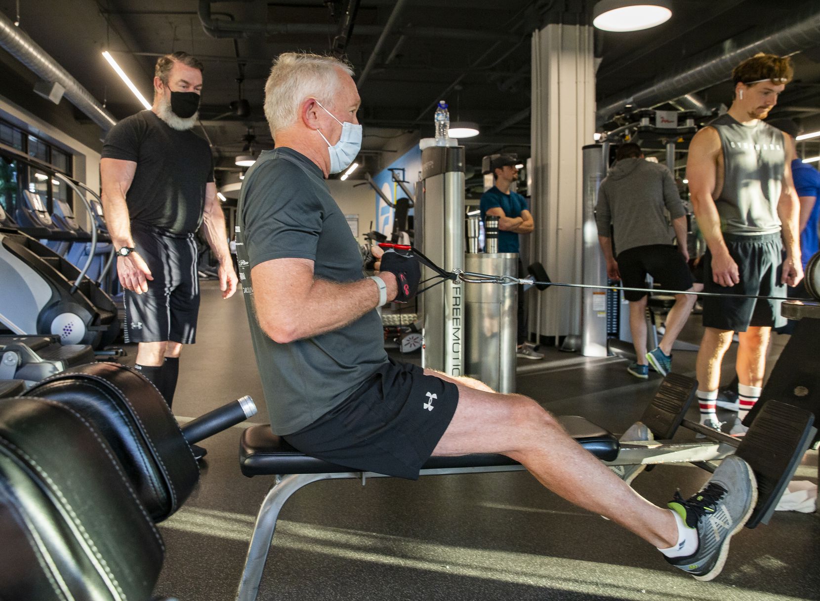 Client Durward Watson of Oak Lawn (center) works out with Trophy Fitness trainer John Gordon (left) at the Uptown gym on May 18, 2020 in Dallas. Watson said he kept active by restoring landscaping and running while the gym was closed. 