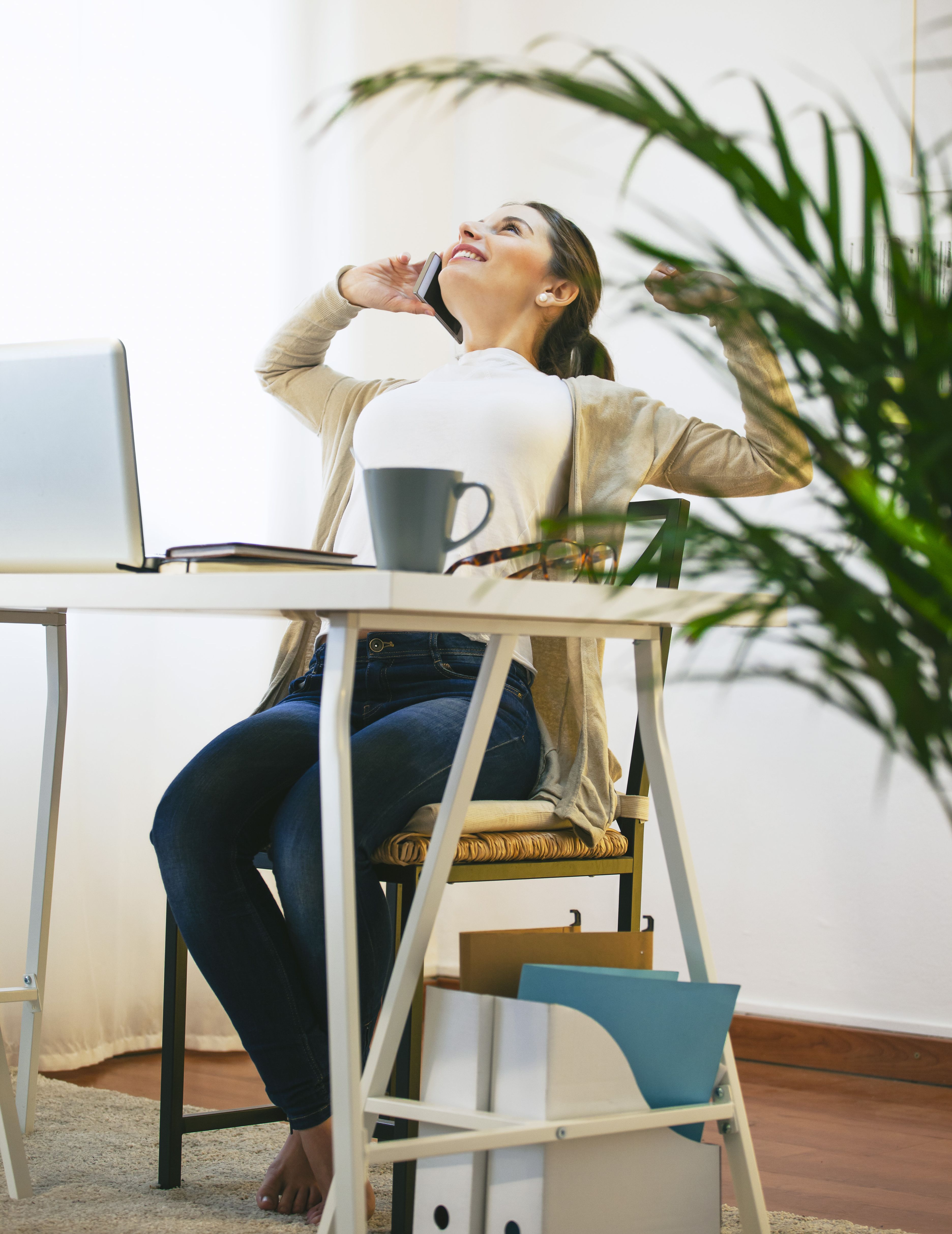 portrait of woman telephoning with smartphone at modern home office