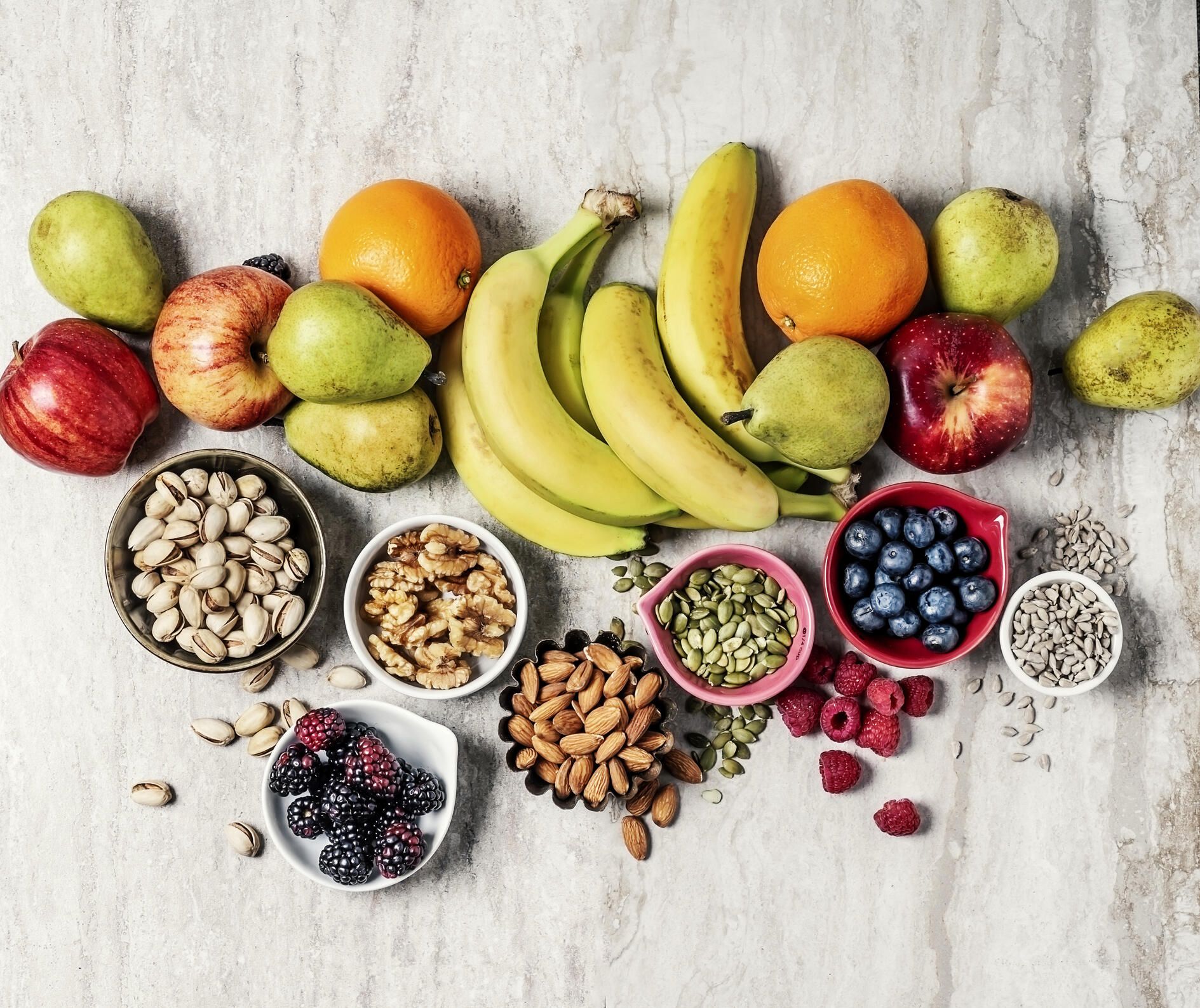 bird's eye view of fruits, nuts and seeds on a granite countertop