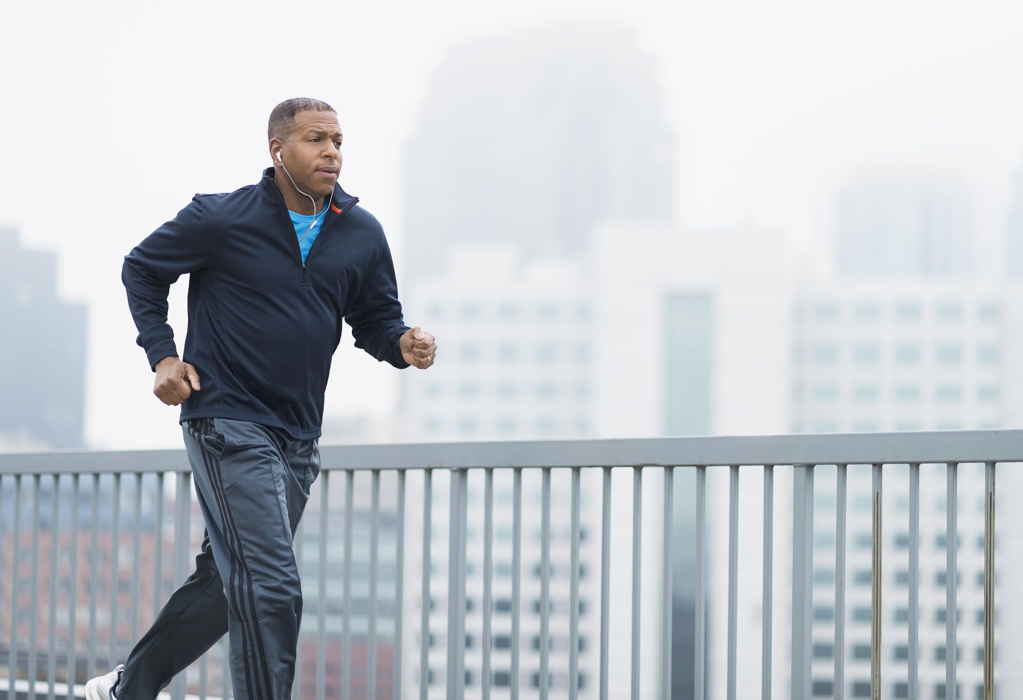 african american man running outside with cityscape background