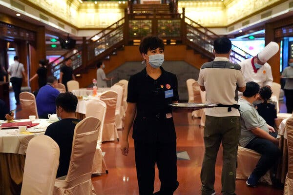 At a restaurant in Beijing, one waiter is also in charge of supervising efforts to avoid food waste. 