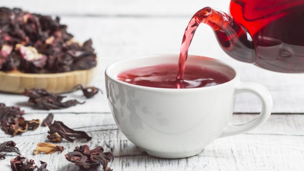 White cup of healthy hibiscus tea pouring from the teapot with dried hibiscus flowers on white wooden background, winter hot drink concept for cold and flu Hibiscus tea
iStock